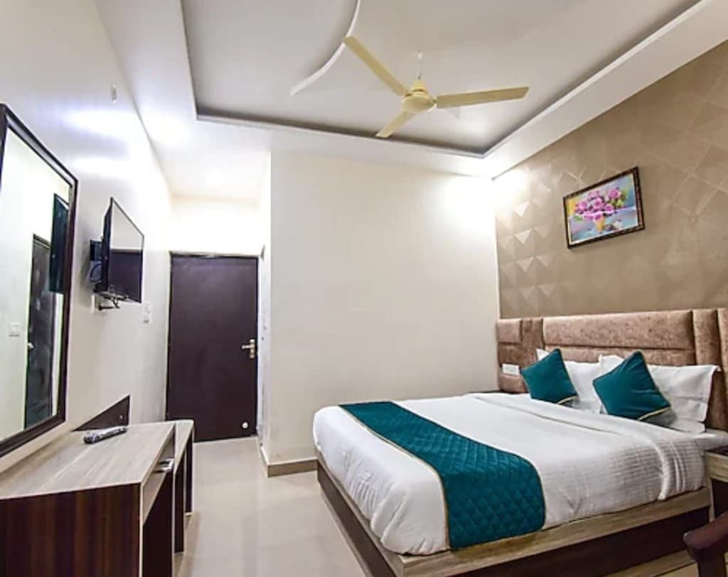 Double Room (AC) wall-mounted LED TV, vanity dressing mirror, and geometric wall pattern