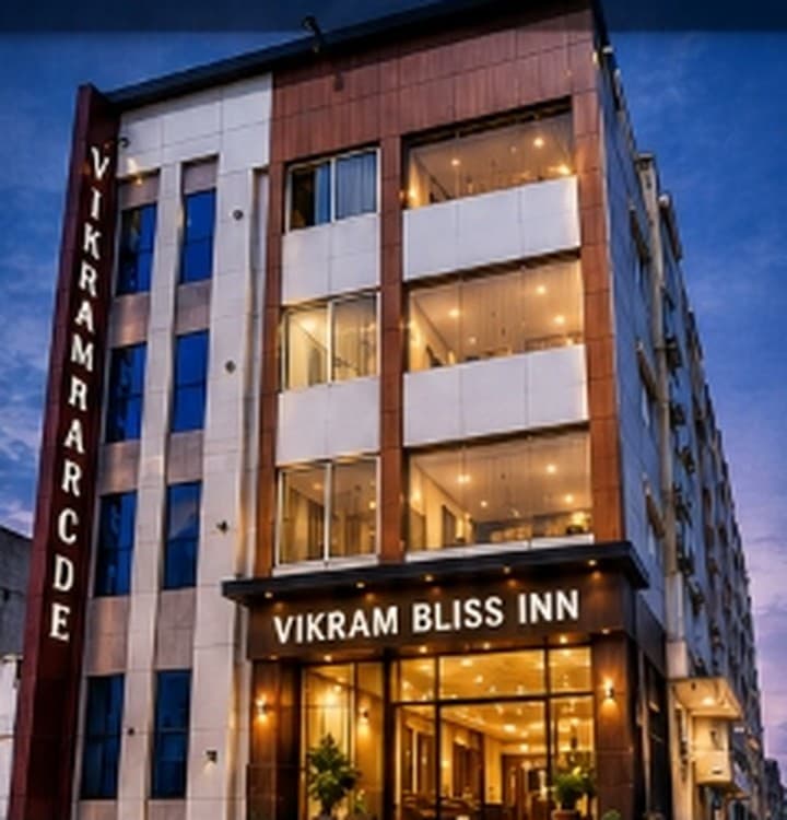 Vikram Bliss Inn multi-storey building illuminated at dusk with signage