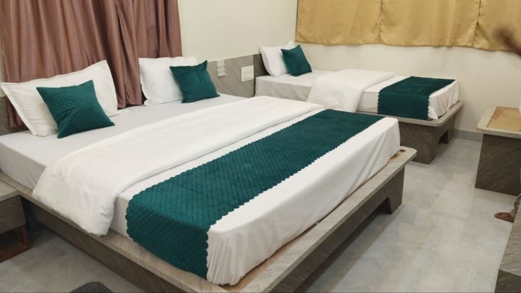 Standard Non-AC Room with two comfortable beds and emerald green runners
